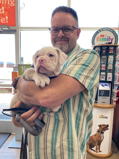 A man holding a light-colored puppy at Petland Eastgate